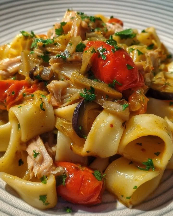 Calamarata con tonno fresco, melanzane e pomodorini in un piatto gourmet