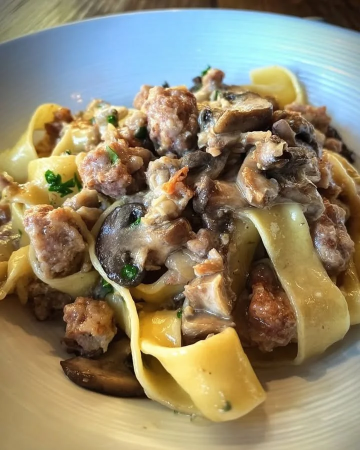 Piatto di pappardelle con salsiccia e funghi, ricco e saporito