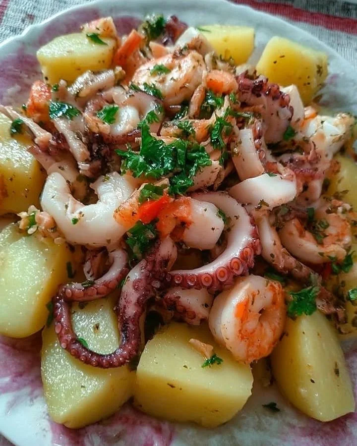 Polpo all’insalata con gamberetti e patate in un piatto colorato