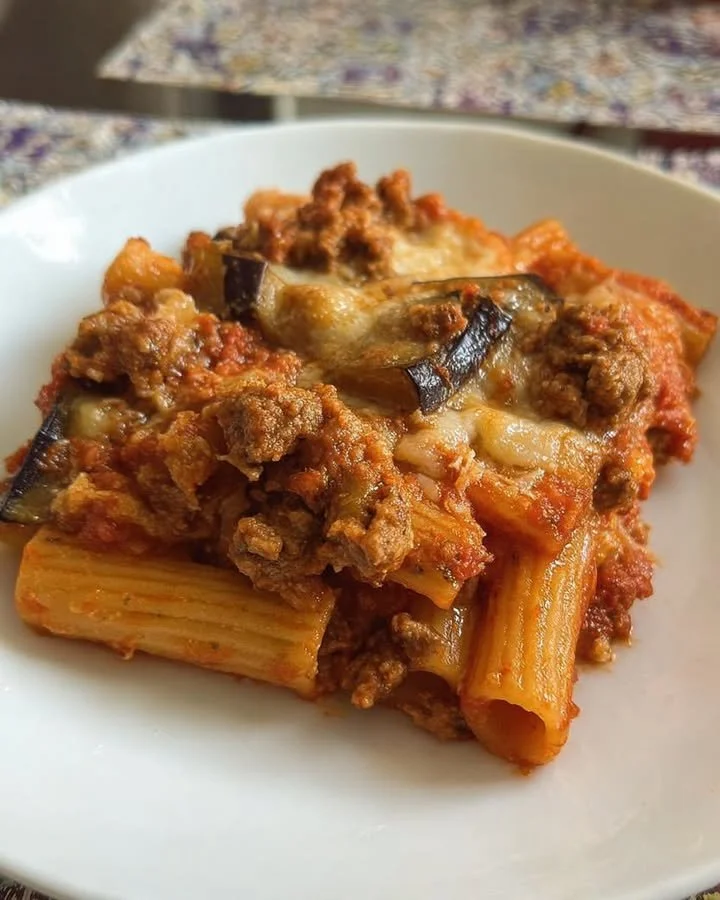 Piatto di rigatoni salsiccia e melanzane al forno, ricetta tradizionale italiana